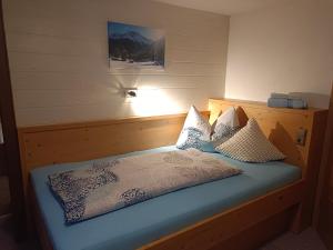 a bedroom with a bed with blue sheets and pillows at Burgerhof in Pettneu am Arlberg +40 photos