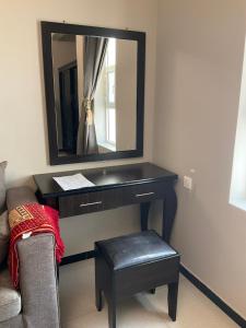 a black desk with a mirror and a stool at khaolha للشقق المخدومة in Al Hofuf +5 photos