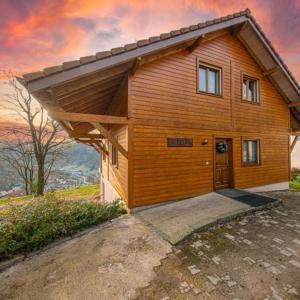 a small wooden house with a large door at Chalet Lipa - Confort et Sauna au cœur des Vosges in La Bresse