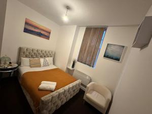 a small bedroom with a bed and a chair at Airrose Rems apartment in Wolverhampton