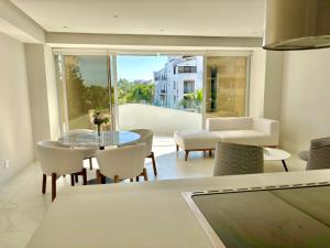 a living room with a glass table and chairs at Park Life Nautico in Nuevo Vallarta 