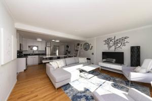 a living room with a white couch and a kitchen at Admiral's Retreat - iTrip Annapolis in Annapolis