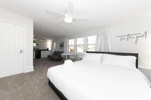 a bedroom with a white bed and a living room at Admiral's Retreat - iTrip Annapolis in Annapolis