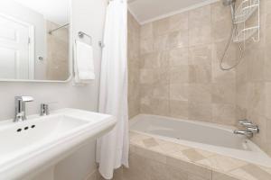 a white bathroom with a sink and a tub at Admiral's Retreat - iTrip Annapolis in Annapolis +39 photos