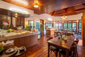 a kitchen and dining room with tables and chairs at Pousada Campos de Provence Campos do Jordão in Campos do Jordão