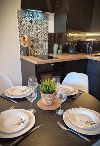 a dining room table with plates and wine glasses at CICADA - Wifi, Clim, Vue Mer, Parking Gratuit in La Ciotat