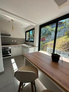 a kitchen with a wooden table and a large window at Forecastle House in Saint-Louis