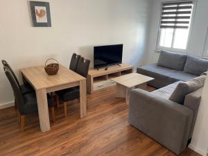 a living room with a couch and a table and a television at Ferienwohnung Funke D6 für Monteure in Apolda