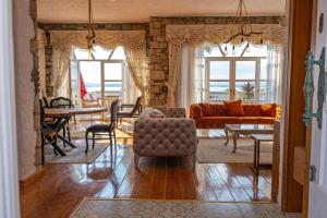 ein Wohnzimmer mit Couch und Tisch in der Unterkunft Fener burnunda Denize sıfır orjinaltaş malikane in Cesme