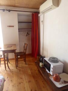 a living room with a microwave and a table at chambre d'hôte calme au milieu d'un jardin au Freney d'oisans in Le Freney-dʼOisans