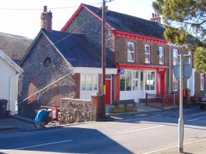 a red brick house on the corner of a street at The Hub at Abercrave in Abercraf