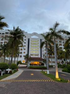 ein großes Gebäude mit Palmen davor in der Unterkunft Ixtapa zihuatanejo, Departamento vacacional- in Zihuatanejo