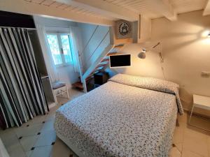 una camera da letto con un letto e un orologio sul muro di VILLA with pool SU PREPPA 'S AUS a Carloforte Altre 48 foto