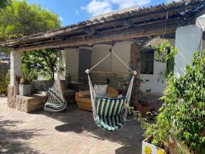 patio con 2 amache appese a un pergolato di VILLA with pool SU PREPPA 'S AUS a Carloforte