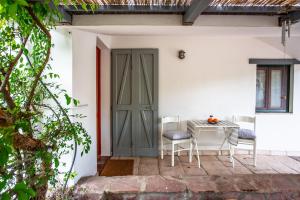 patio con tavolo, sedie e porta di VILLA with pool SU PREPPA 'S AUS a Carloforte