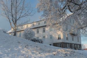 a building on a hill with snow on the ground at Fokhol Gård Gjestehus in Stange
