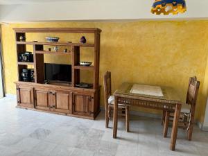 ein Esszimmer mit einem Tisch und einem Entertainment-Center in der Unterkunft Ixtapa zihuatanejo, Departamento vacacional- in Zihuatanejo