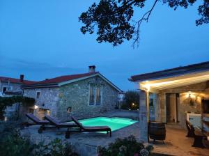 a backyard with a pool and a house at Villa Nono in Vrh