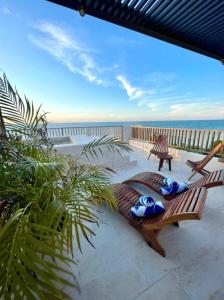 a patio with chairs and a view of the ocean at Breathtaking Ocean Vista Penthouse with Private Pool in Holbox Island