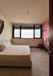 a bedroom with a bed and a large window at Breathtaking Ocean Vista Penthouse with Private Pool in Holbox Island