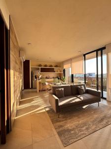 a large living room with a couch and a kitchen at Breathtaking Ocean Vista Penthouse with Private Pool in Holbox Island