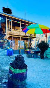 a building with two colorful umbrellas in front of it at Apple hills Resort in Jibhi