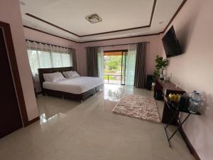 a bedroom with a bed and a television in it at Jindarin Villas จินดาริน คาเฟ่ in Ban Nong Sarai (1) +53 photos