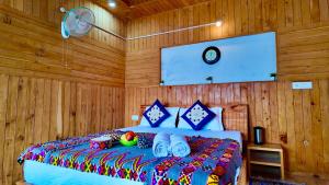 a bedroom with a bed with wooden walls at Apple hills Resort in Jibhi