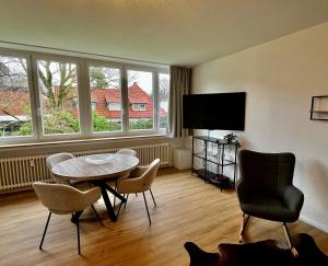 a living room with a table and chairs and a tv at Ferienwohnung Studio LANA in Bad Zwischenahn