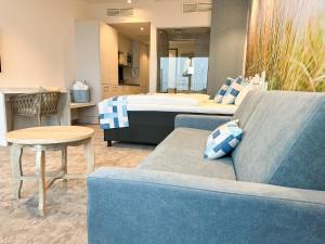 a living room with a couch and a bed at SlowDown Bottsand Hotel und Spa in Wendtorf +36 photos
