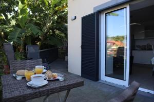 a table with food and two cups of orange juice at Casa do Tio Albino II, By OP in Ponta Delgada