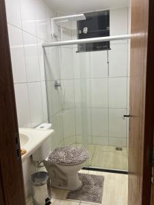a bathroom with a shower and a toilet and a sink at Apto luxo 2 min centro in Governador Valadares
