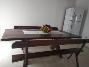 miska owoców na drewnianym stole z lodówką w obiekcie Casa são Miguel dos milagres w mieście São Miguel dos Milagres +1 zdjęcie