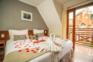 a bedroom with a bed with red roses on it at Pousada Campos de Provence Campos do Jordão in Campos do Jordão +41 photos