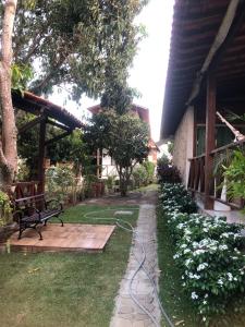 een tuin met een bankje en een tuinslang bij Horizonte da serra 1 in Gravatá