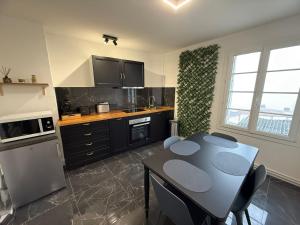 a kitchen with a table with chairs and a tableasteryasteryasteryasteryasteryastery at Le Rossignol 1 er etage in Avranches