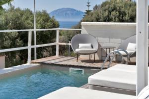 a patio with two chairs and a swimming pool at Increíble Villa de madera con vistas al mar in Algeciras