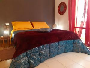 a bed with orange and blue sheets on top of it at Casa Dellestate in Grottammare