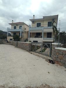 a large house with a fence in front of it at Μαρία 4 in Káto Almirí