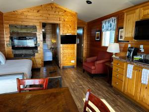 a hotel room with a bed and a kitchen and a room at Westport Marina Cottages in Westport