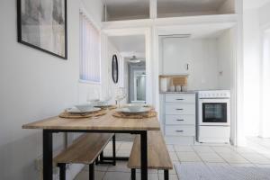 eine Küche mit einem Holztisch mit Weingläsern in der Unterkunft 4-Bedroom Central Canterbury Cottage in Kent