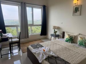 a bedroom with a bed and a desk and windows at Platinum - Sun-kissed Holidays Goa in Dabolim