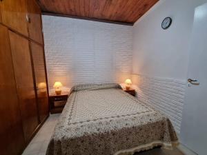 a bedroom with a bed and two lamps on tables at Casa Mardel in Mar del Plata