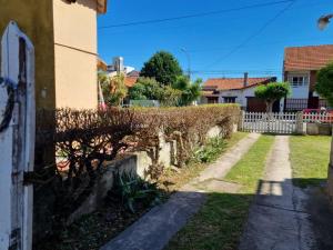 an alley in a house with a hedge at Casa Mardel in Mar del Plata +2 photos