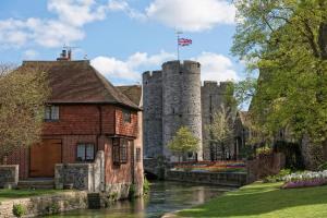 ein Gebäude mit einer Flagge auf einem Schloss in der Unterkunft 4-Bedroom Central Canterbury Cottage in Kent