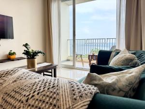 a living room with a couch and a large window at Platinum - Sun-kissed Holidays Goa in Dabolim