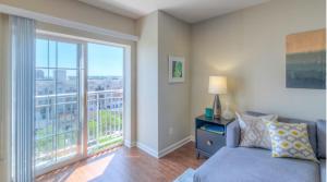 een woonkamer met een bank en een groot raam bij National at Clarendon Metro in Arlington