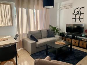a living room with a couch and a tv at La Repera Jaén in Jaén
