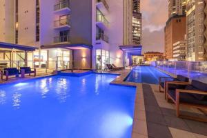 a swimming pool with blue lights in a building at Great Value CBD 2 Beds Apt Free Carpark Pool and Gym in Brisbane