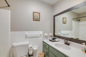a bathroom with a toilet and a sink and a mirror at 4 Mi to Shelby Farms Park Memphis Home with Patio! in Memphis +17 photos